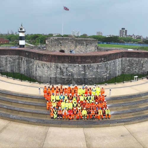 People in highvis sat on the steps of the Southsea Coastal Scheme.