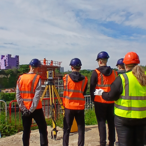 People in highvis on a site tour of the New Wear high-level Footbridge sign.
