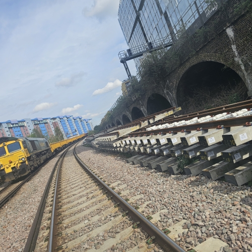 Track with new track next to it and a freight train