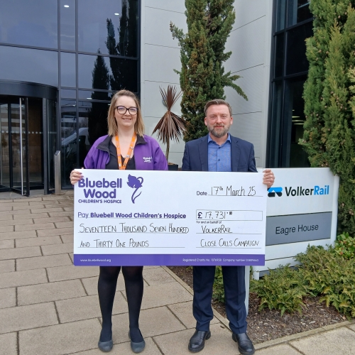 Two people holding a big cheque