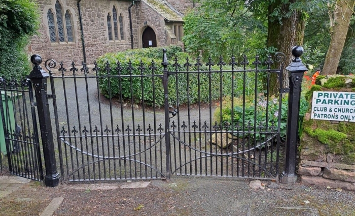 A black iron fence outside a church yard