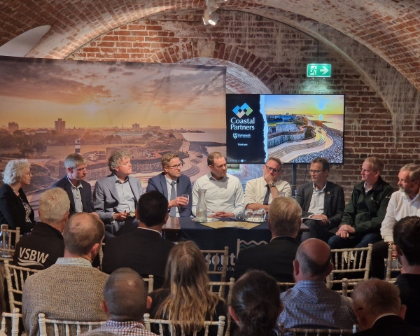People sat around a table in front of an audience